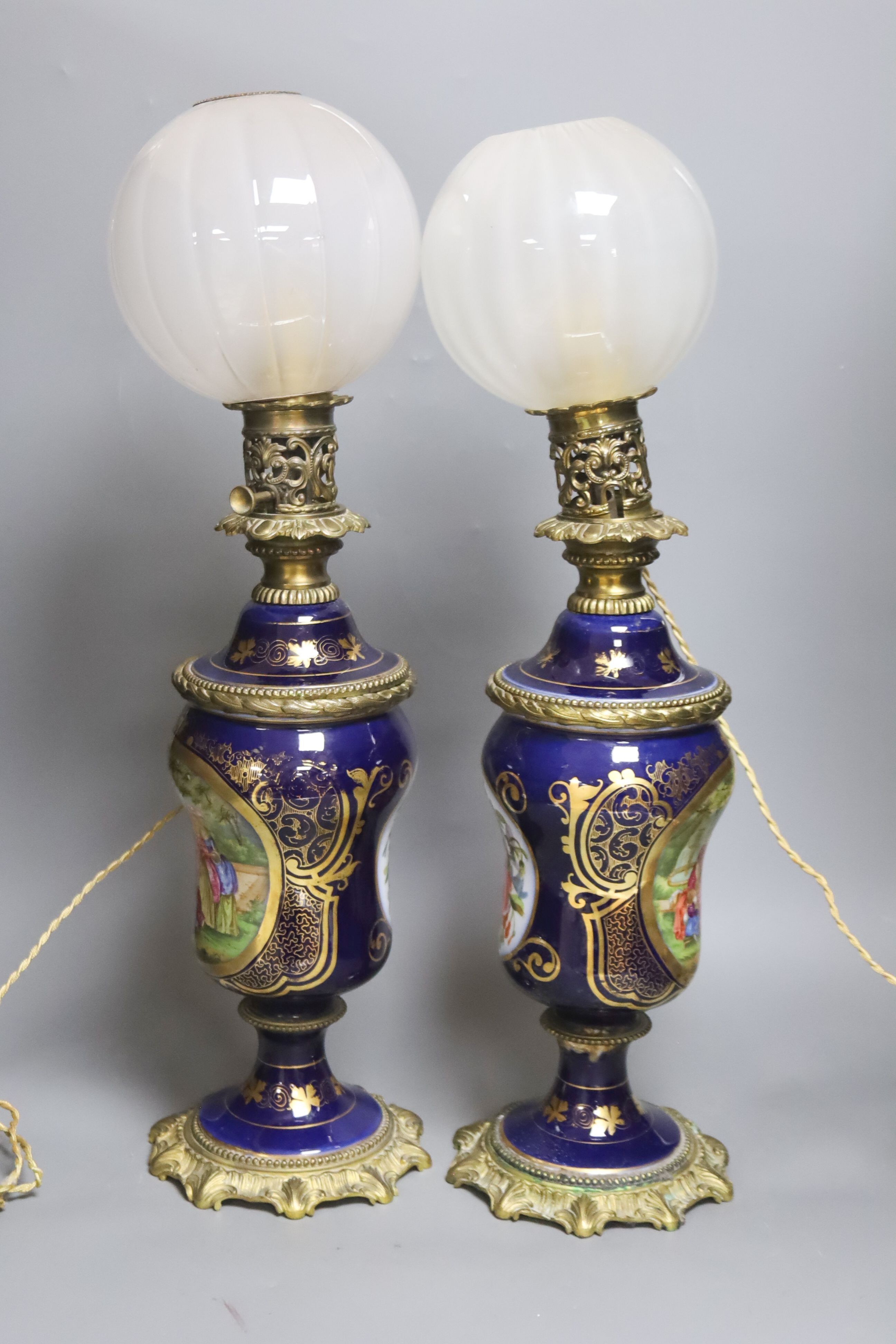 A matched pair of hand-painted Paris porcelain converted oil lamps 57cm